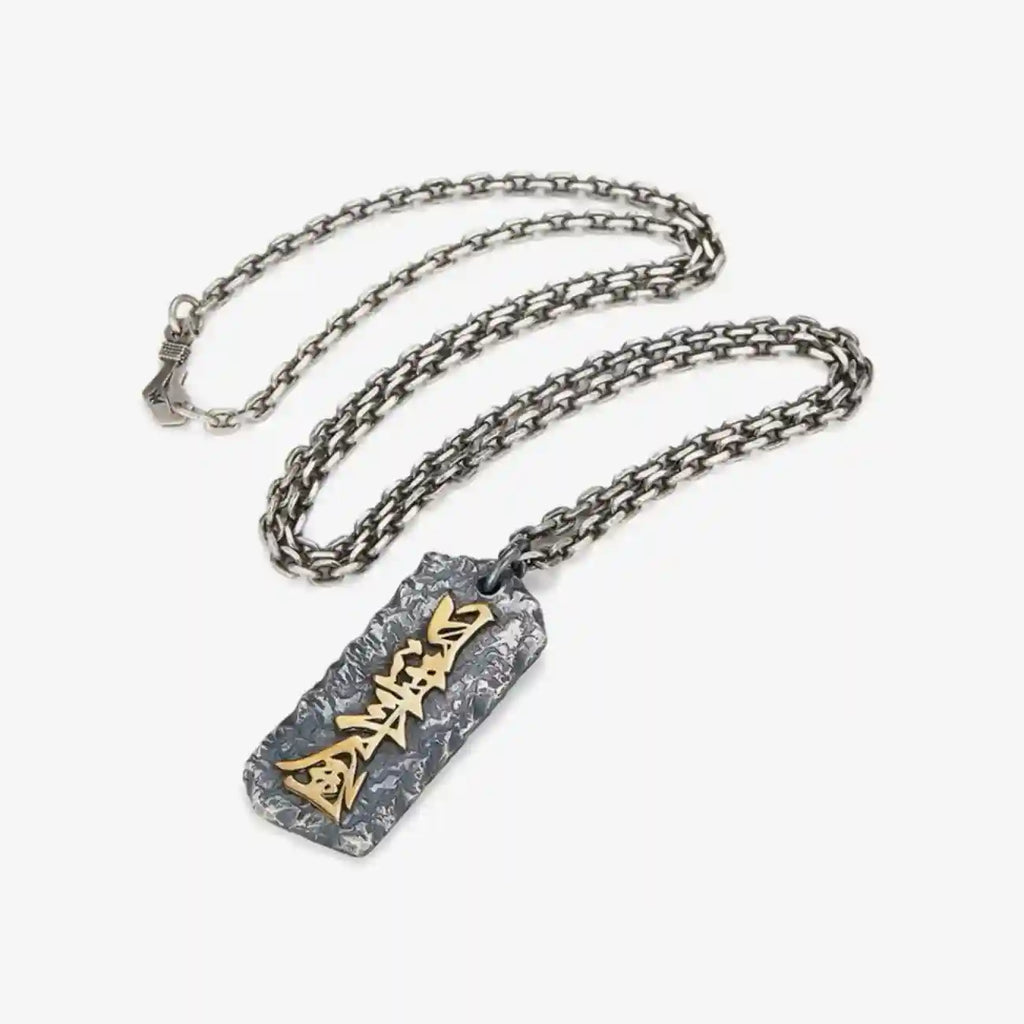 Flat lay of the Abundance necklace with a silver chain, displaying the rectangular tag design