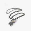 Flat lay of the antique silver chain paired with the rectangular Fortune Key pendant