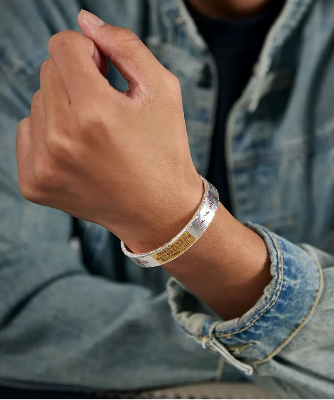 A relaxed lifestyle shot showing the bangle on the wrist, highlighting the golden accents and vermilion text in natural light