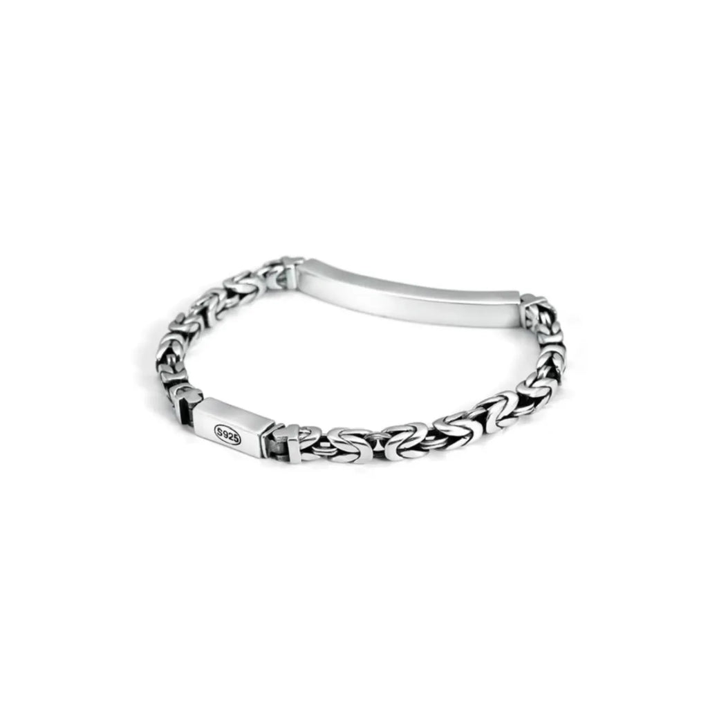 Side profile showing the unique grid-like architectural detailing on the edge of the silver bar