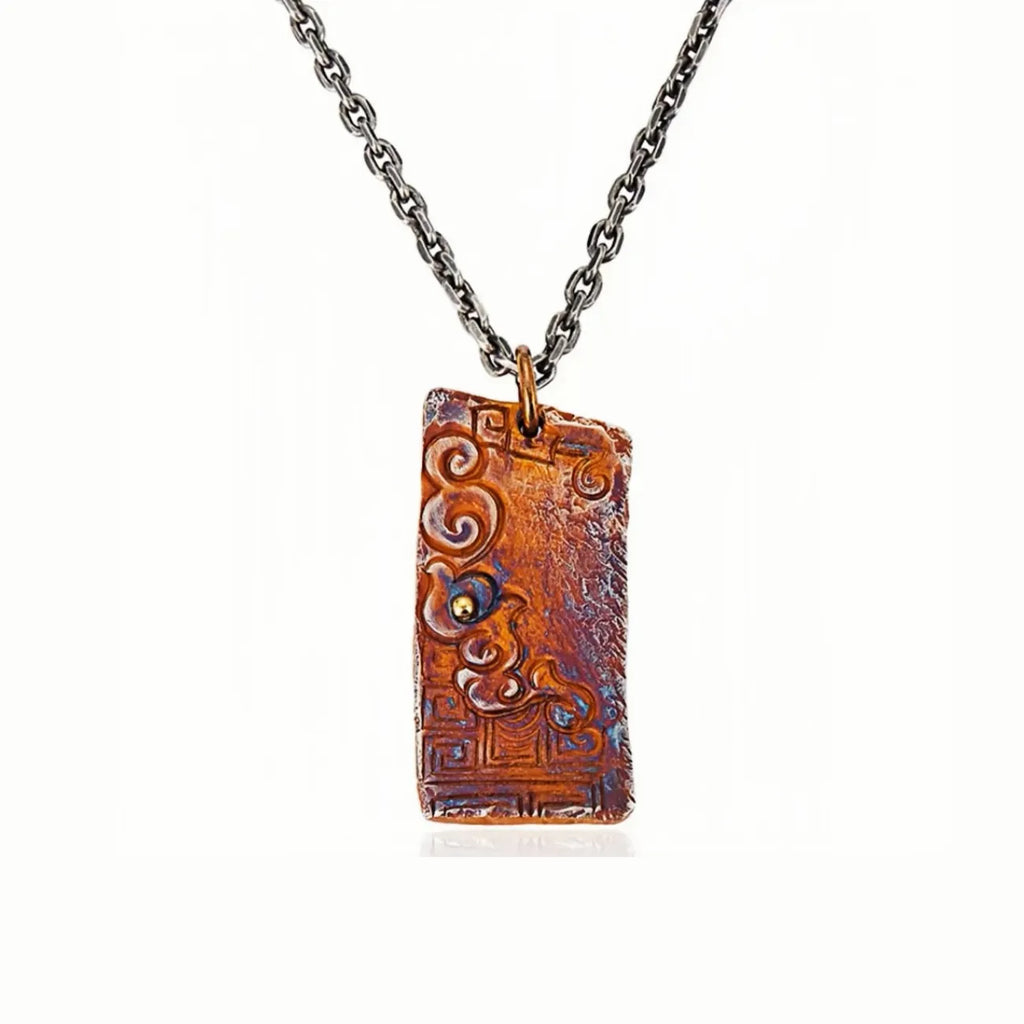 Front view of the serenity necklace showing the rectangular pendant with auspicious cloud relief and a small golden bead