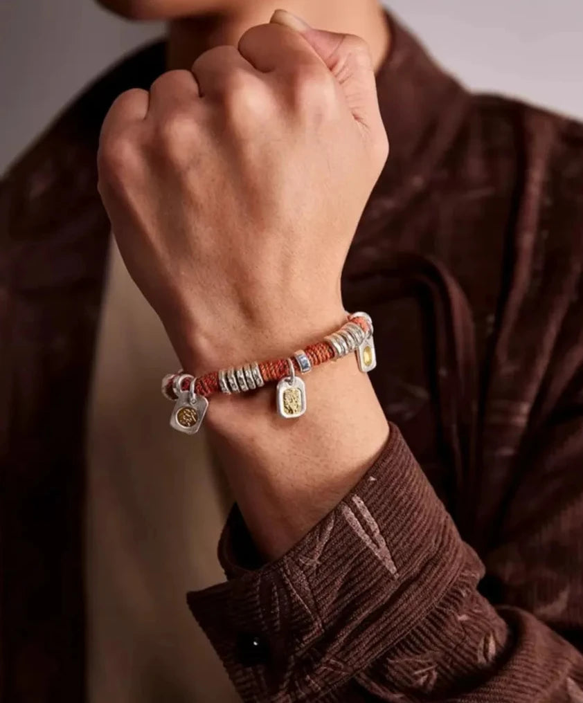 Lifestyle shot of a man in a brown corduroy shirt wearing the 'Fortune Trinity' bracelet, evoking a sense of harvest and abundance