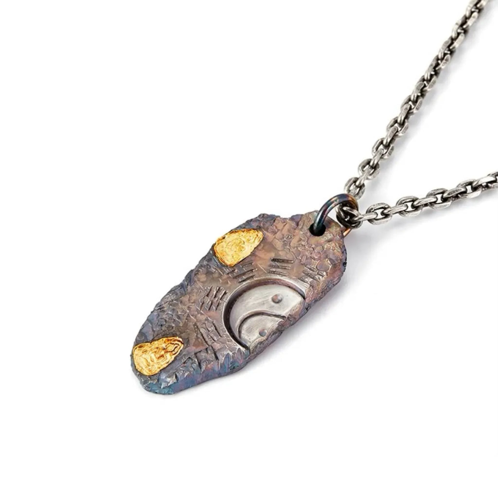 Angled shot of the Bagua necklace, highlighting the rufous bronze tones and textured metal surface