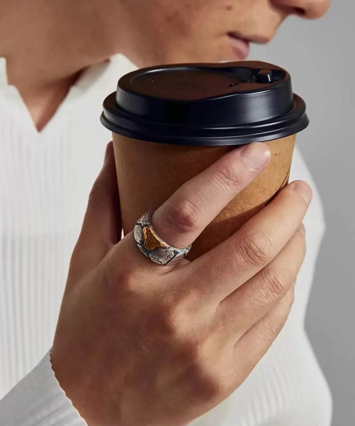Lifestyle shot of the Bedrock Ring worn while holding coffee, perfect as a unique mixed metal gift for him