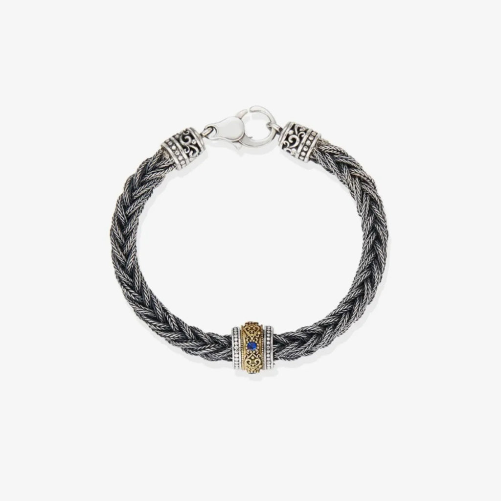 Top-down view highlighting the deep blue gemstone set within the golden bronze scrollwork