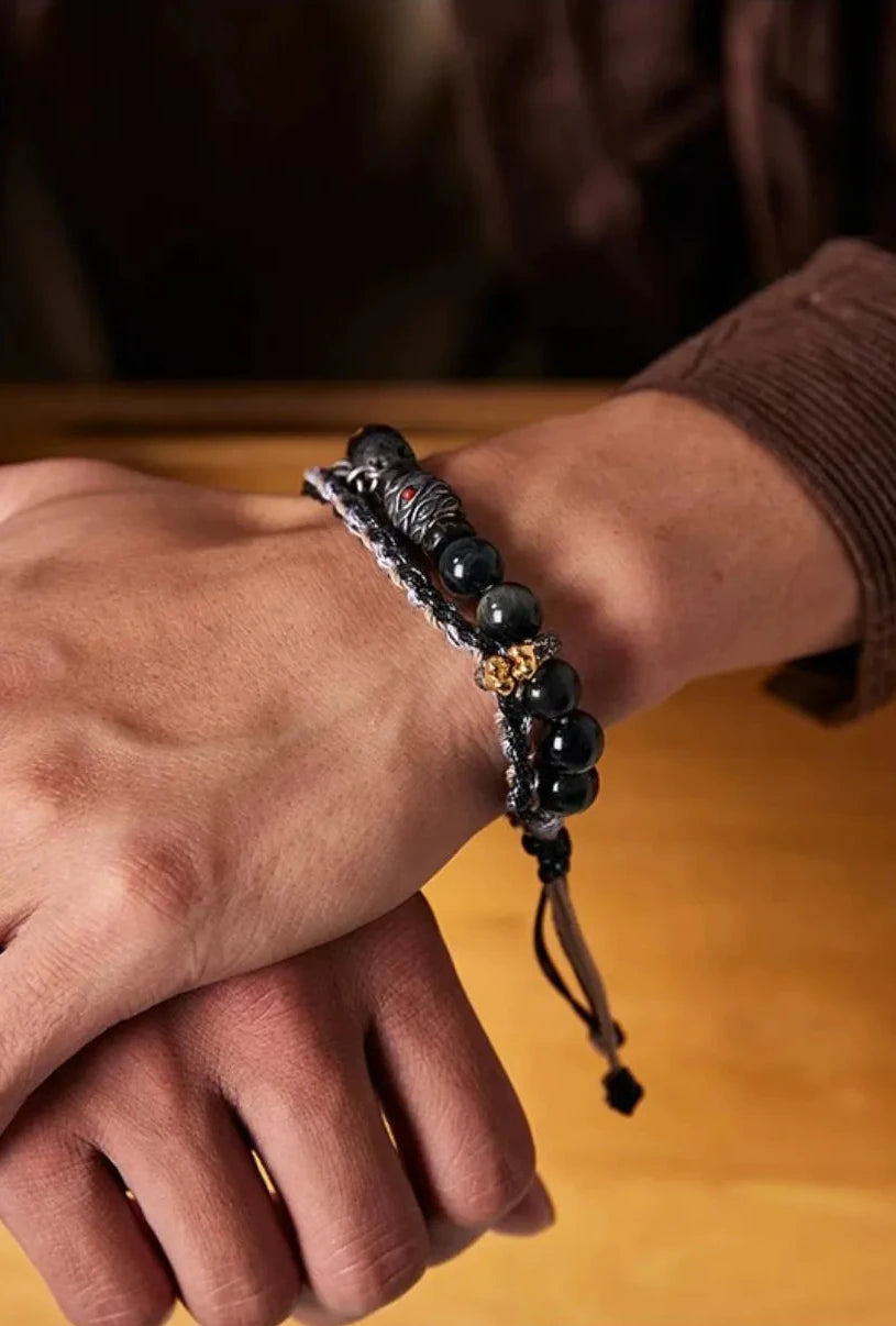 Close-up showing the mystical blue sheen of the hawk's eye stones and the intricate silver details of the Monkey King charm