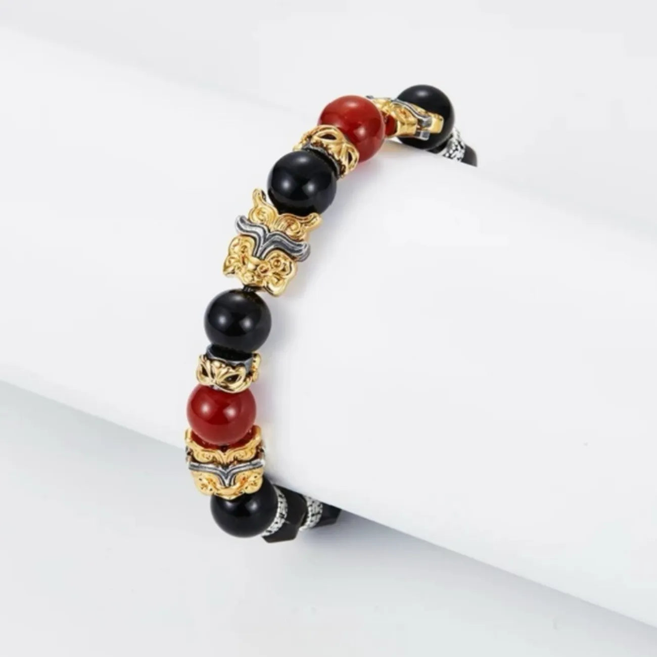 Side profile showing the detailed gold and silver plating on the Taotie beast and the vibrant red carnelian stone