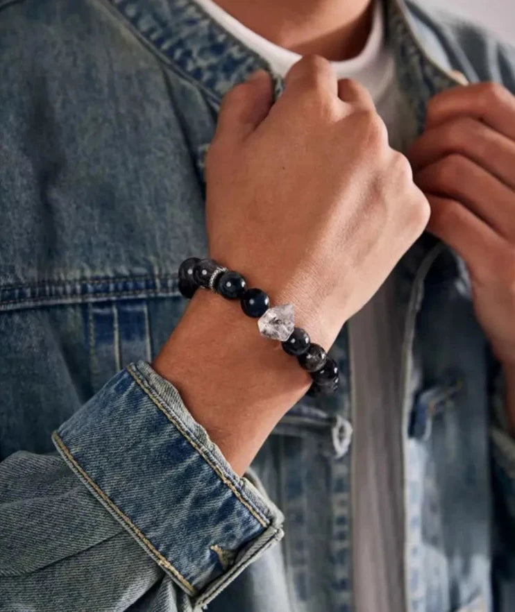 Lifestyle shot of a man wearing a denim jacket, showcasing the blue tiger eye bracelet as a stylish casual accessory