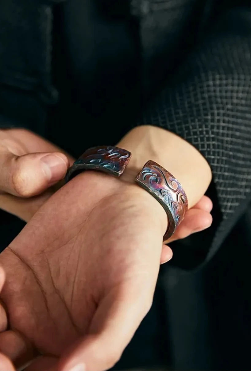 Close-up of the inner wrist showing the open ends of the bangle and the rich rufous and blue color gradient