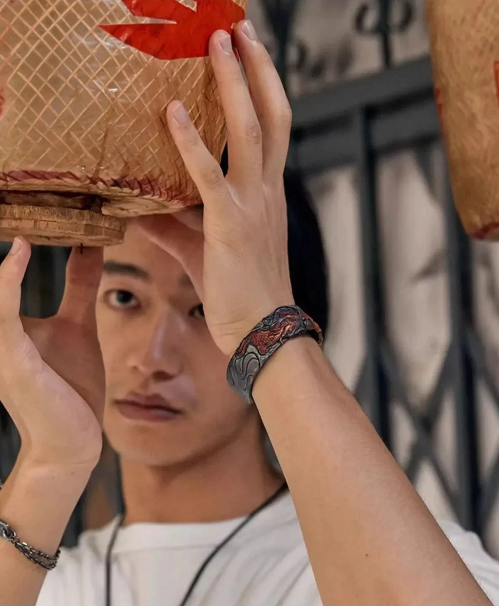A candid shot of a model raising his hand, featuring the dragon bangle as a statement piece in a casual outfit