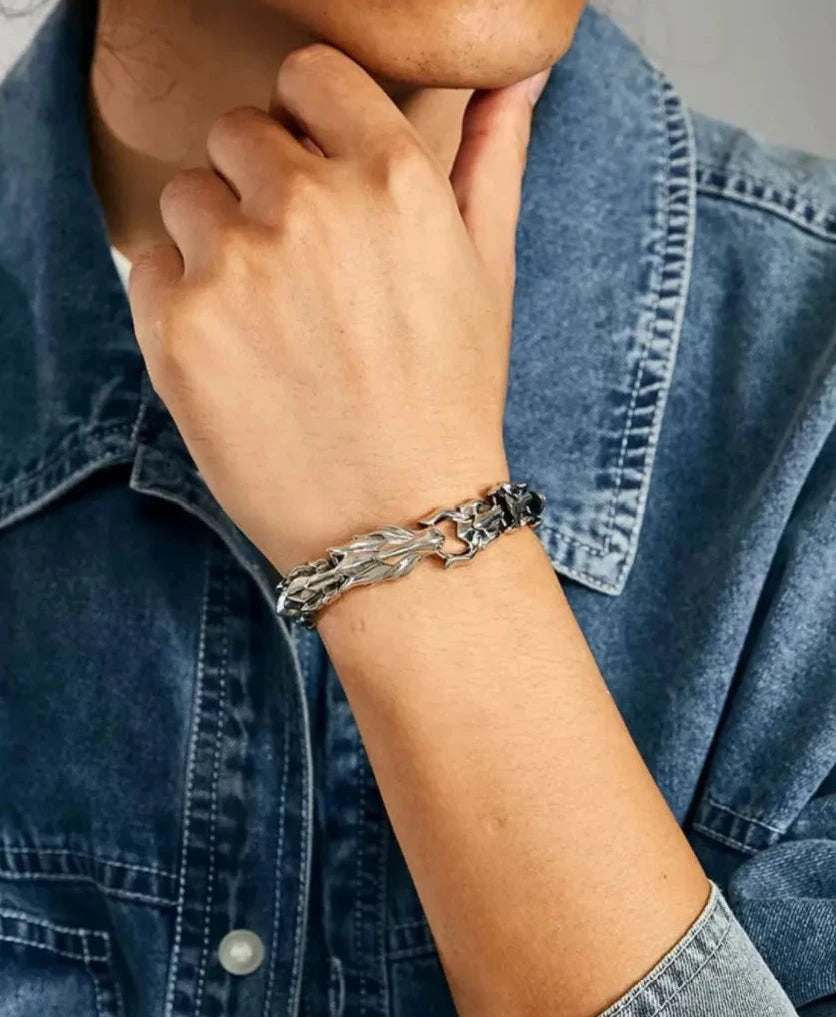 A contemplative pose showcasing the bracelet's scale texture and how it complements a rugged fashion style