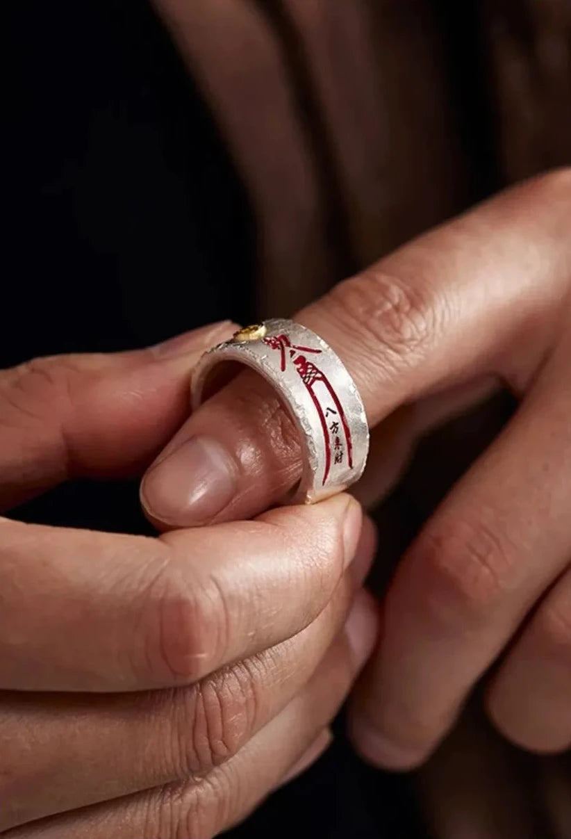 Extreme close-up showing the matte texture and vermilion script of the ring on the finger