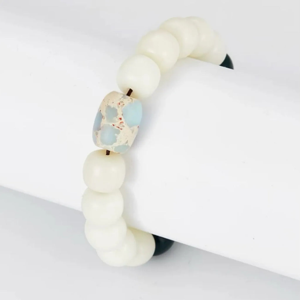 Side detail showing the antique silver spacer and black accent beads creating a Yin-Yang balance against the white Bodhi seeds