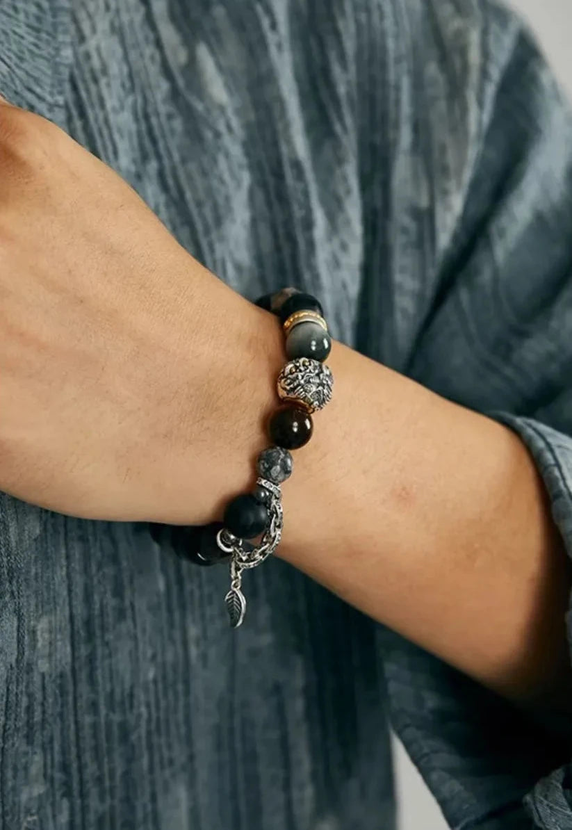 Lifestyle shot of a man wearing the Pixiu wealth bracelet, pairing the grey earthy stones with a textured grey linen shirt