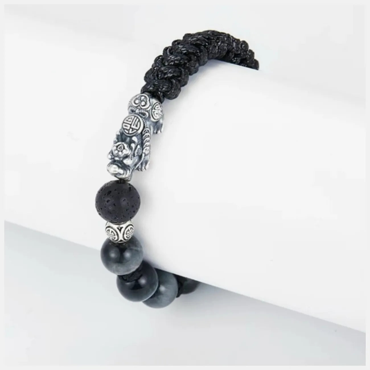 Top-down view highlighting the silver Pixiu beast, known for attracting wealth, resting between natural stones