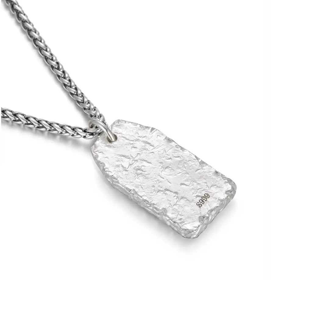 Back view of the solid silver pendant displaying a rugged hammered texture and S999 purity stamp