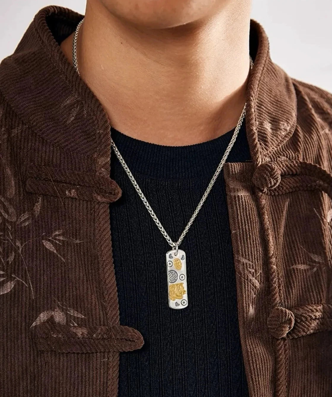 Model wearing the lucky cat necklace styled with a brown corduroy jacket and black shirt