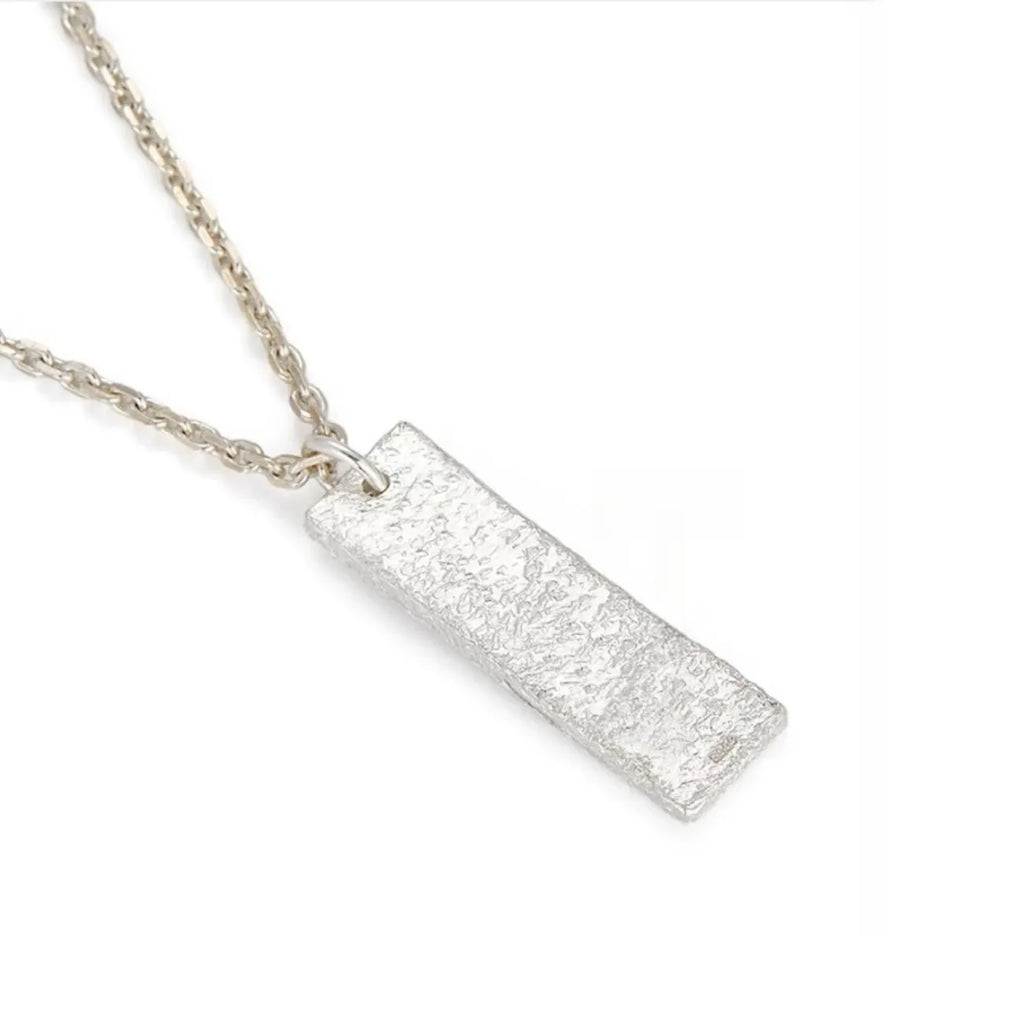 Angled shot of the rectangular silver pendant showing the rugged ice-cracked texture