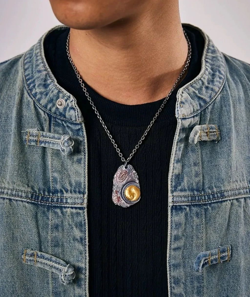 Model wearing the Taichi necklace with a denim jacket, showcasing the pendant's drop length