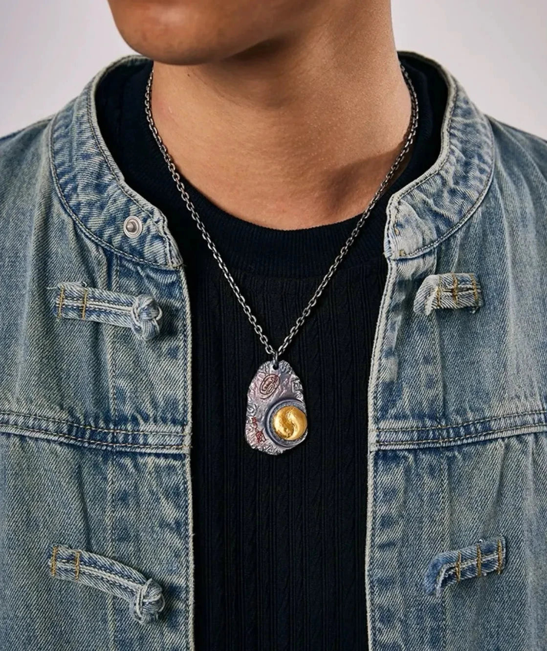 Model wearing the Taichi necklace with a denim jacket, showcasing the pendant's drop length