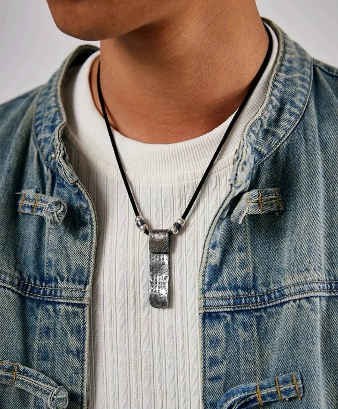 Male model wearing the handmade amulet cord necklace with denim jacket