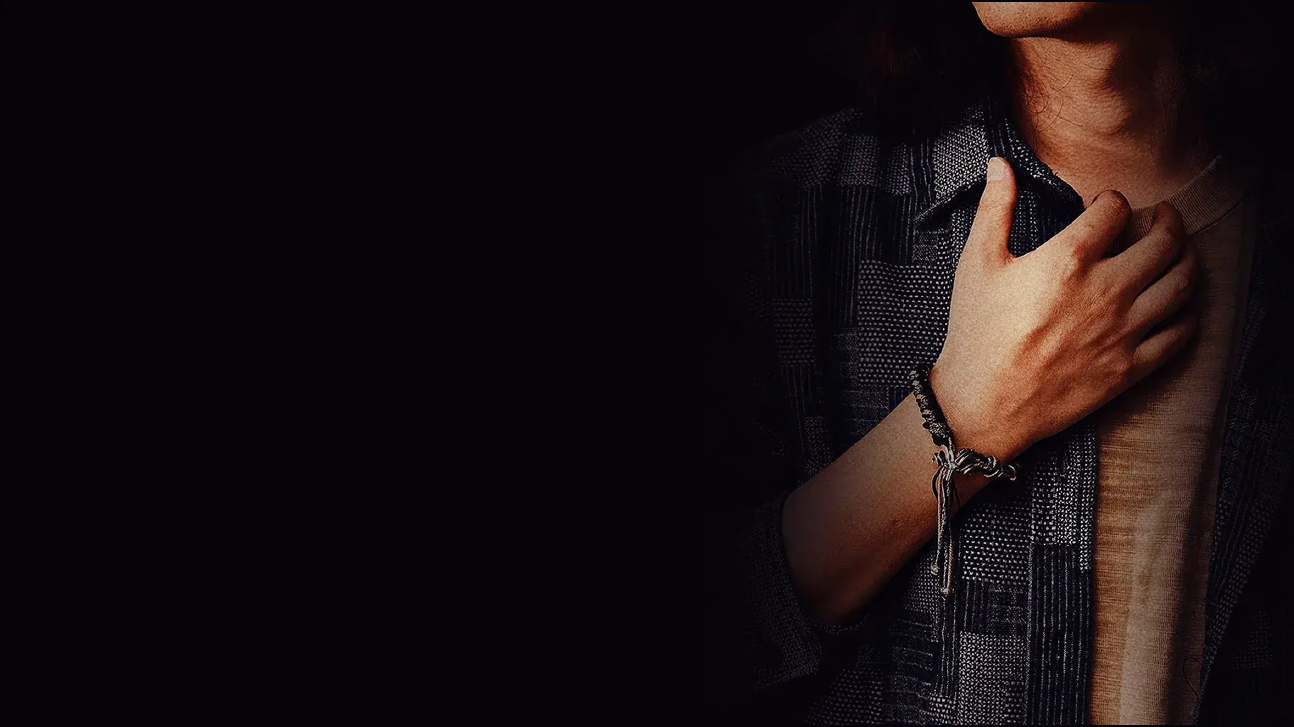 A male model showcasing a minimalist handcrafted silver woven bracelet, highlighting its textured details.