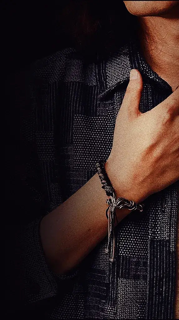 A male model showcasing a minimalist handcrafted silver woven bracelet, highlighting its textured details