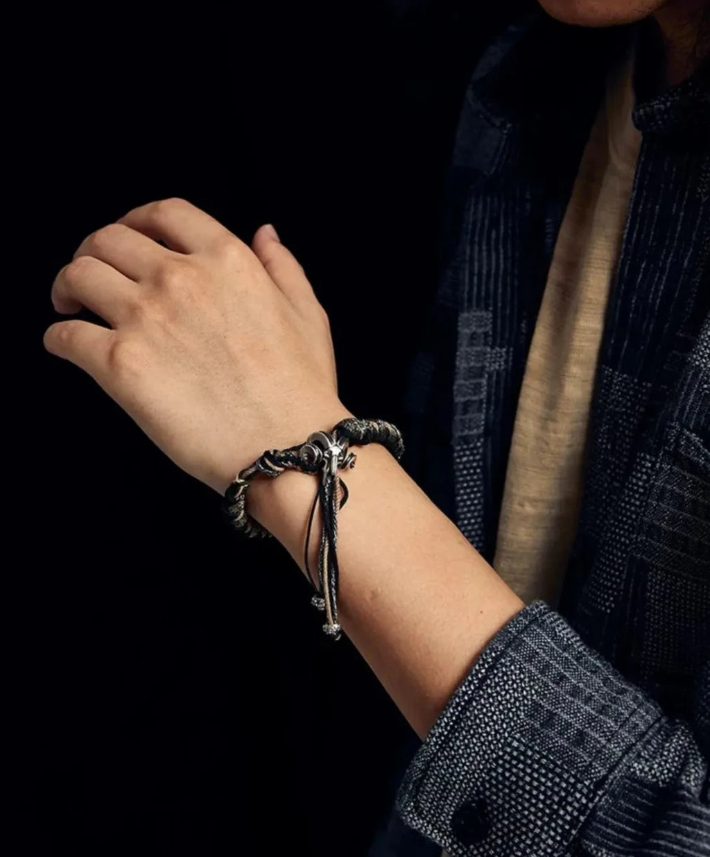 Close-up lifestyle shot showing how the Ram Skull functions as a toggle clasp with hanging tassels for a nomadic look