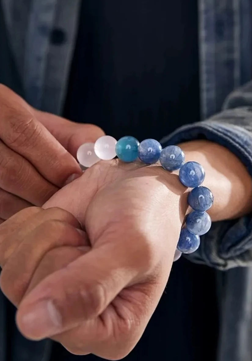 Close-up on the wrist under natural light, revealing the stunning silky luster and cat-eye effect of the high-quality kyanite beads
