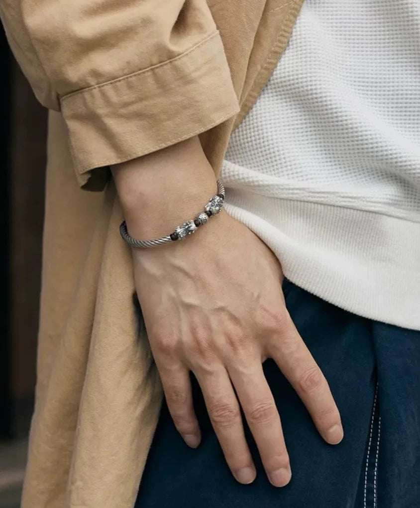 Lifestyle shot of a man in a beige trench coat wearing the silver Pixiu cuff, blending tradition with modern style