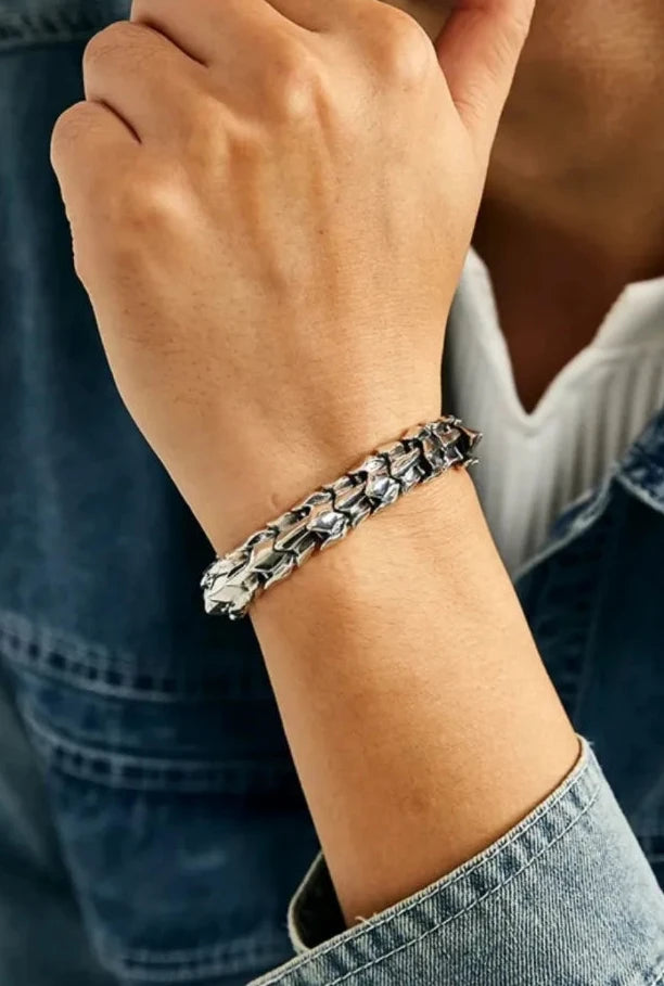 Lifestyle shot of a man in a denim jacket wearing the dragon spine bracelet, showing its fit on the wrist