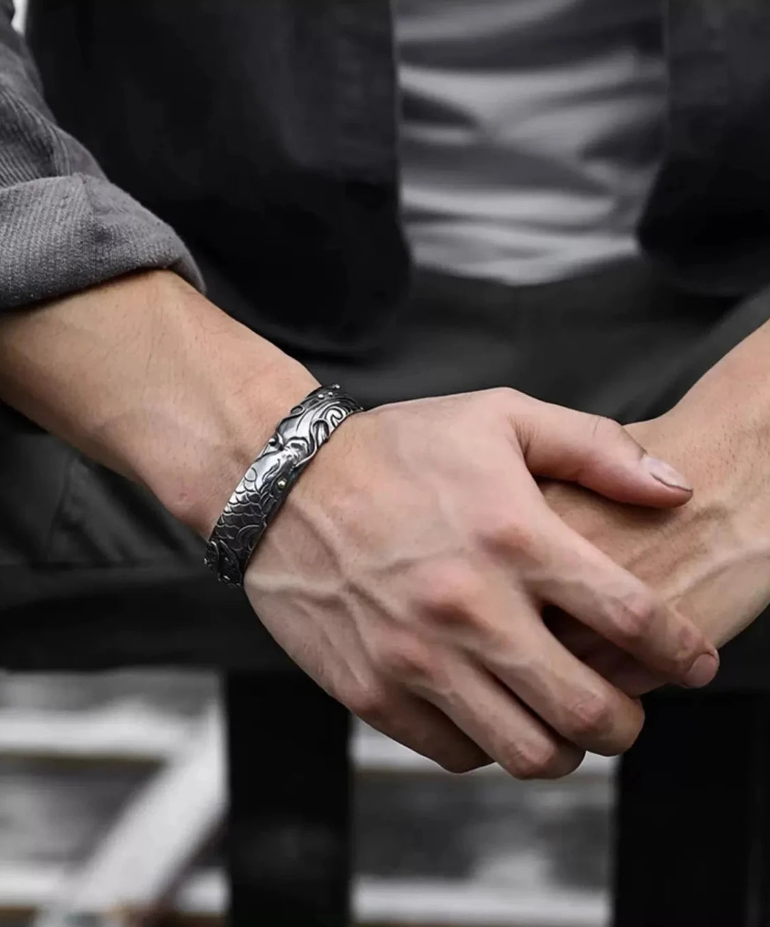 Lifestyle shot of a man's arm with visible veins, wearing the dragon carp bangle which complements a rugged, masculine aesthetic