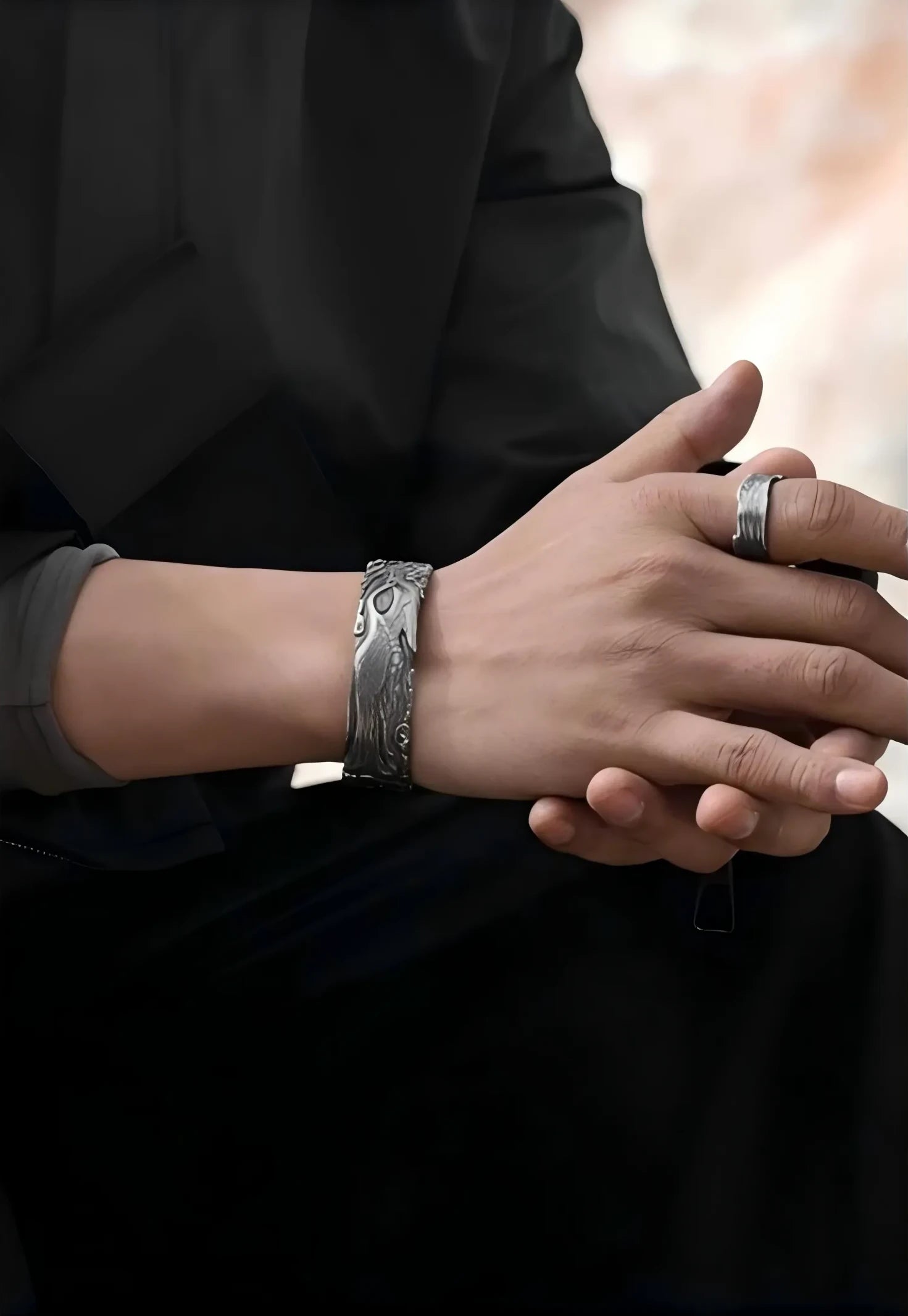 Close-up of the model's clasped hands, showcasing the crane bangle as a symbol of peace and mindfulness