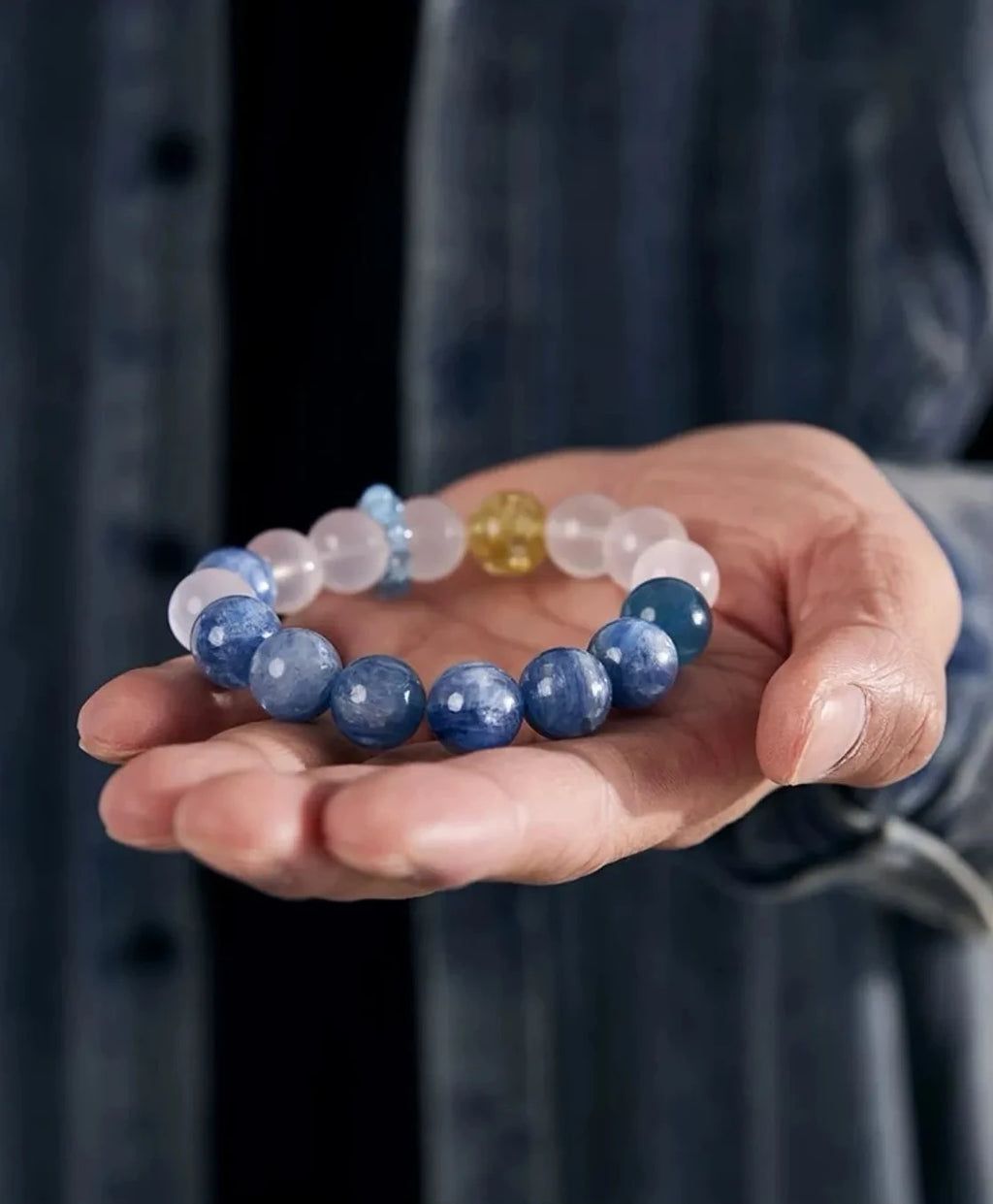 A bracelet resting in a man's palm, emphasizing the tactile quality and the calming, healing energy of the natural stones