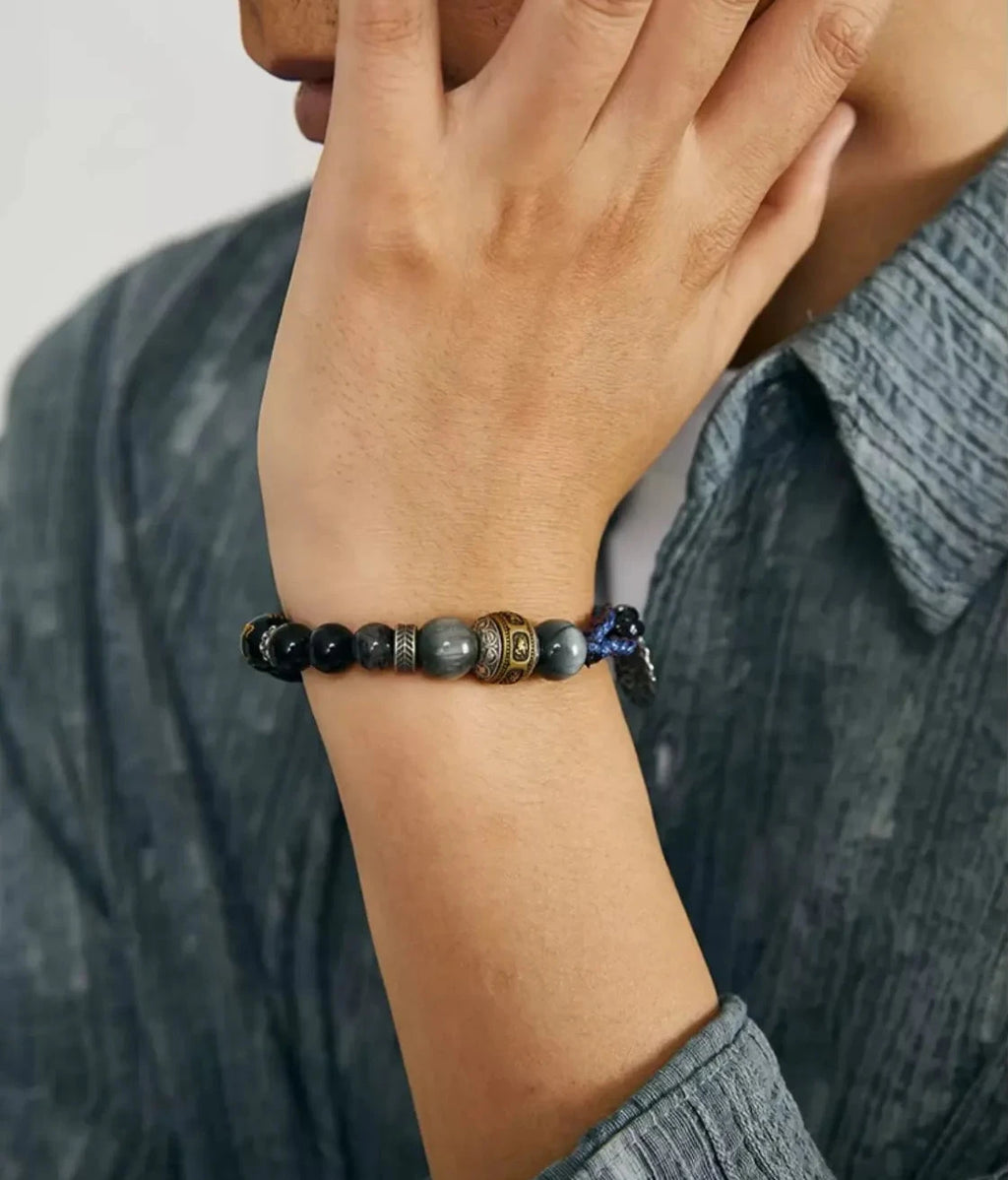 Lifestyle shot of a man wearing the Sunyata bracelet, showcasing the contrast between the royal blue woven cord and the grey eagle eye beads