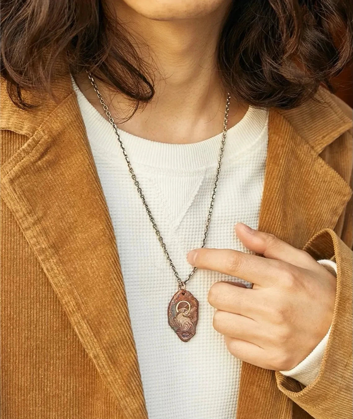 Fashion shot of a man wearing the Celestial Stag necklace with a casual white shirt and jacket