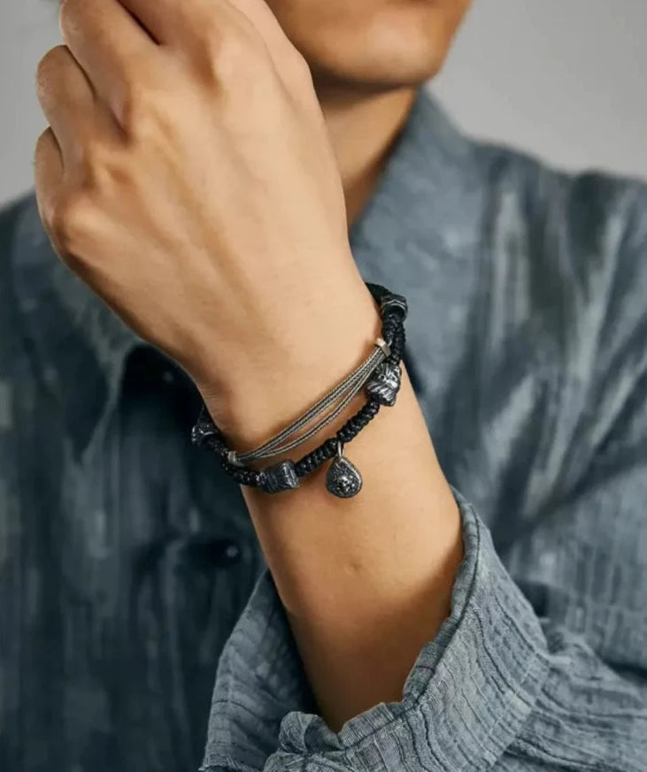 Detailed shot emphasizing the contrast between the oxidized silver skull charm and the crinkled blue fabric of the shirt