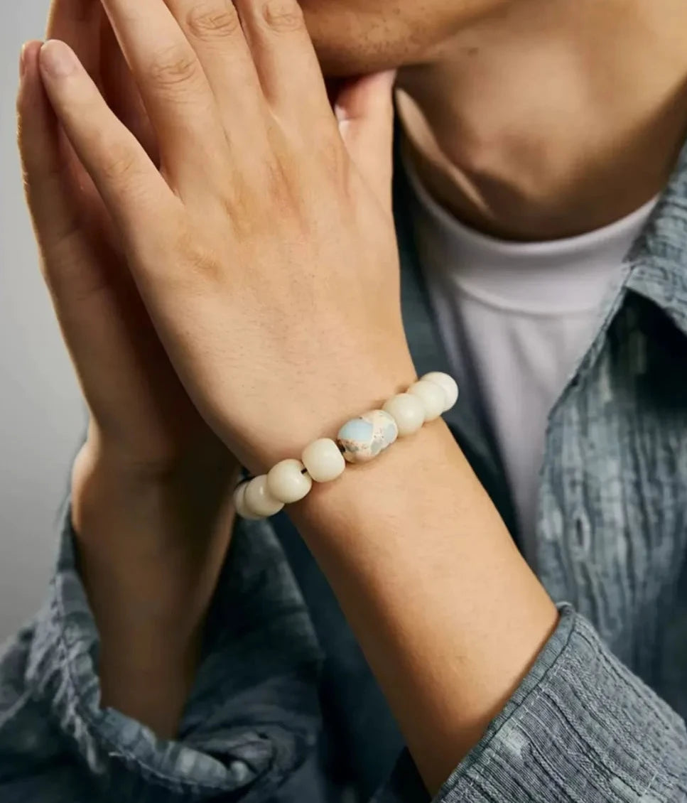 A contemplative shot of a man in a prayer pose, wearing the Bodhi bracelet, symbolizing inner peace, wisdom, and boundless compassion