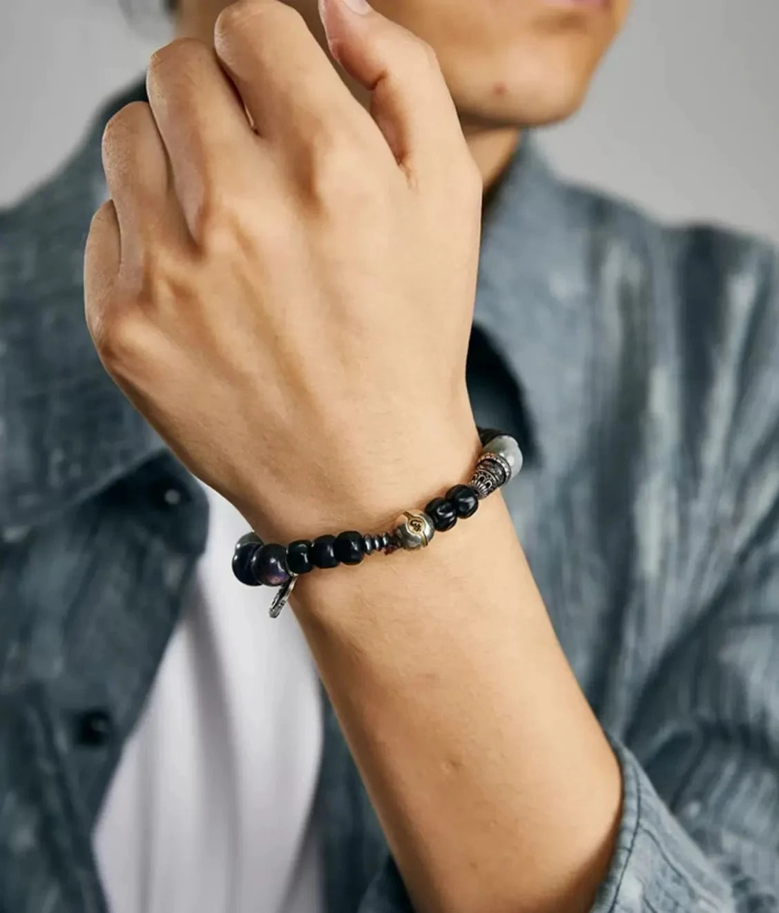A man wearing the meditation bracelet, highlighting the central gold-accented spiritual bead and its calming aesthetic