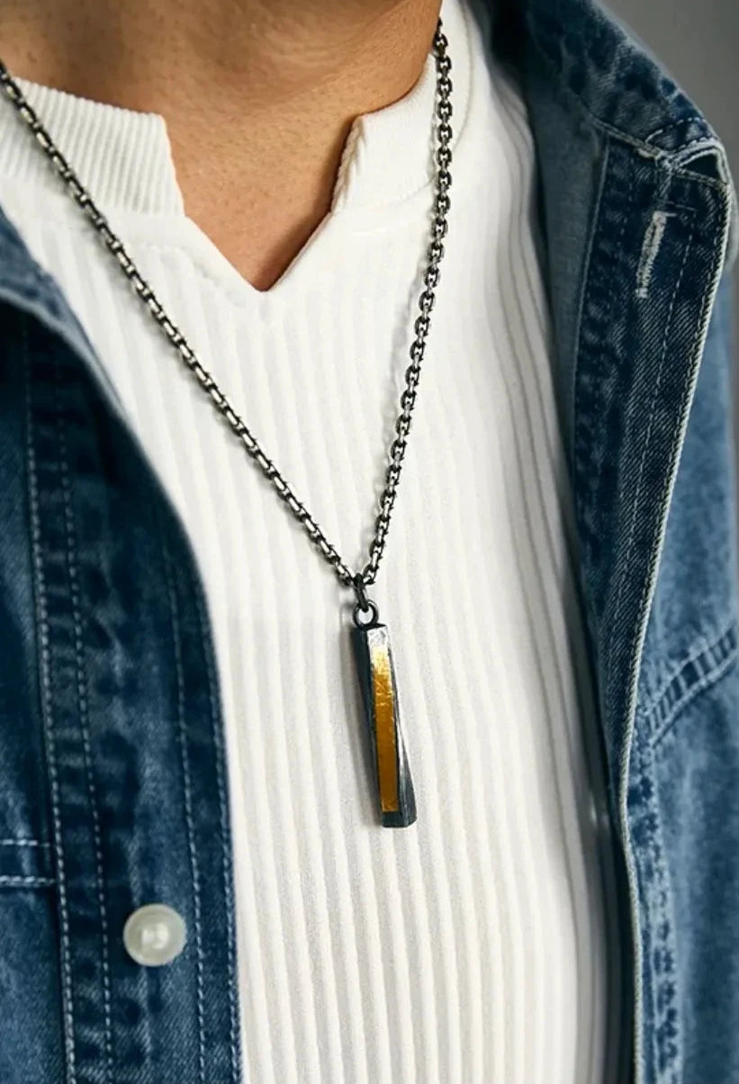 Model wearing the necklace with a denim shirt, showing how the gold accent catches the light