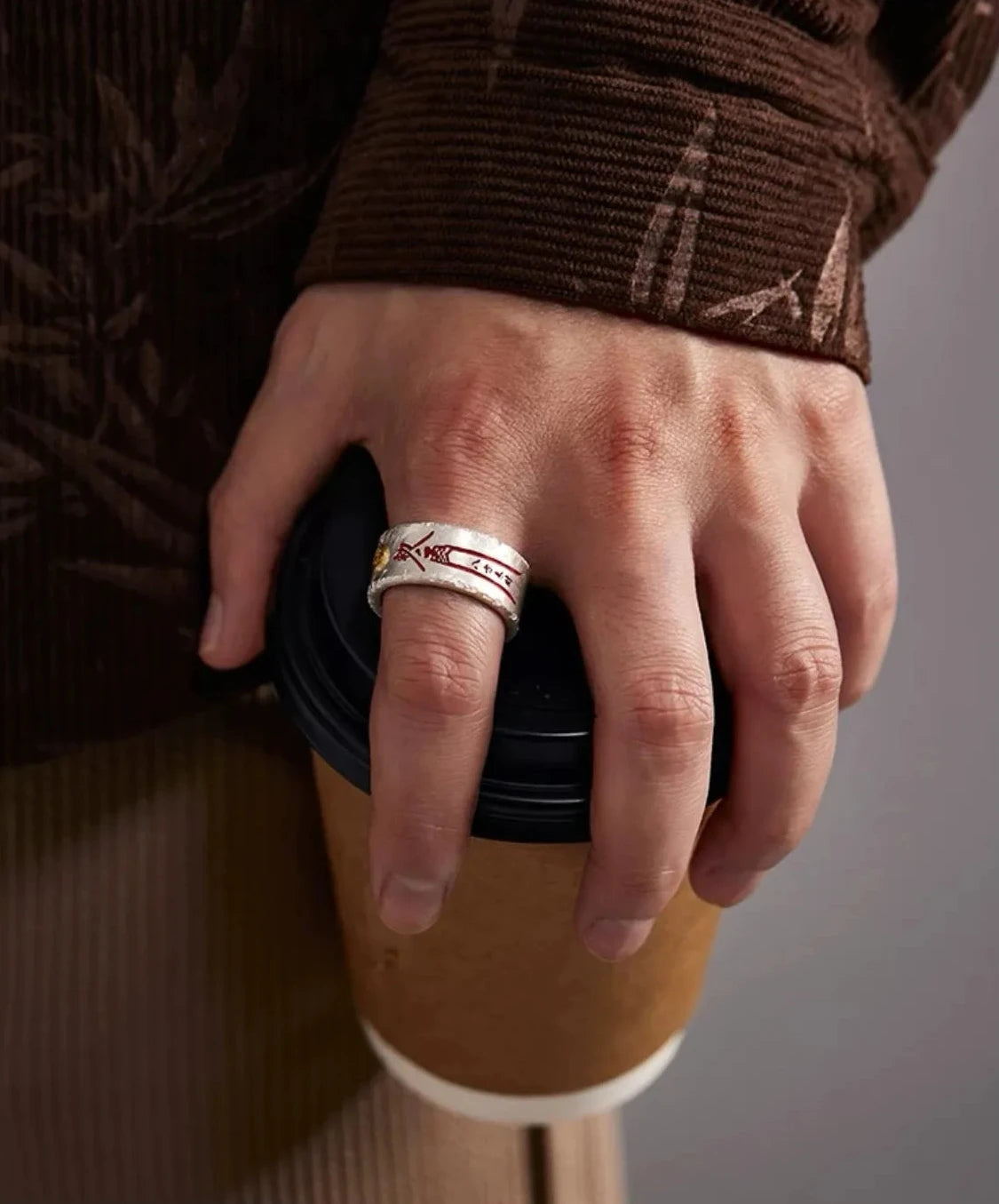 Model posing with the silver and gold Taoism amulet ring, showcasing the red cinnabar script against a dark background