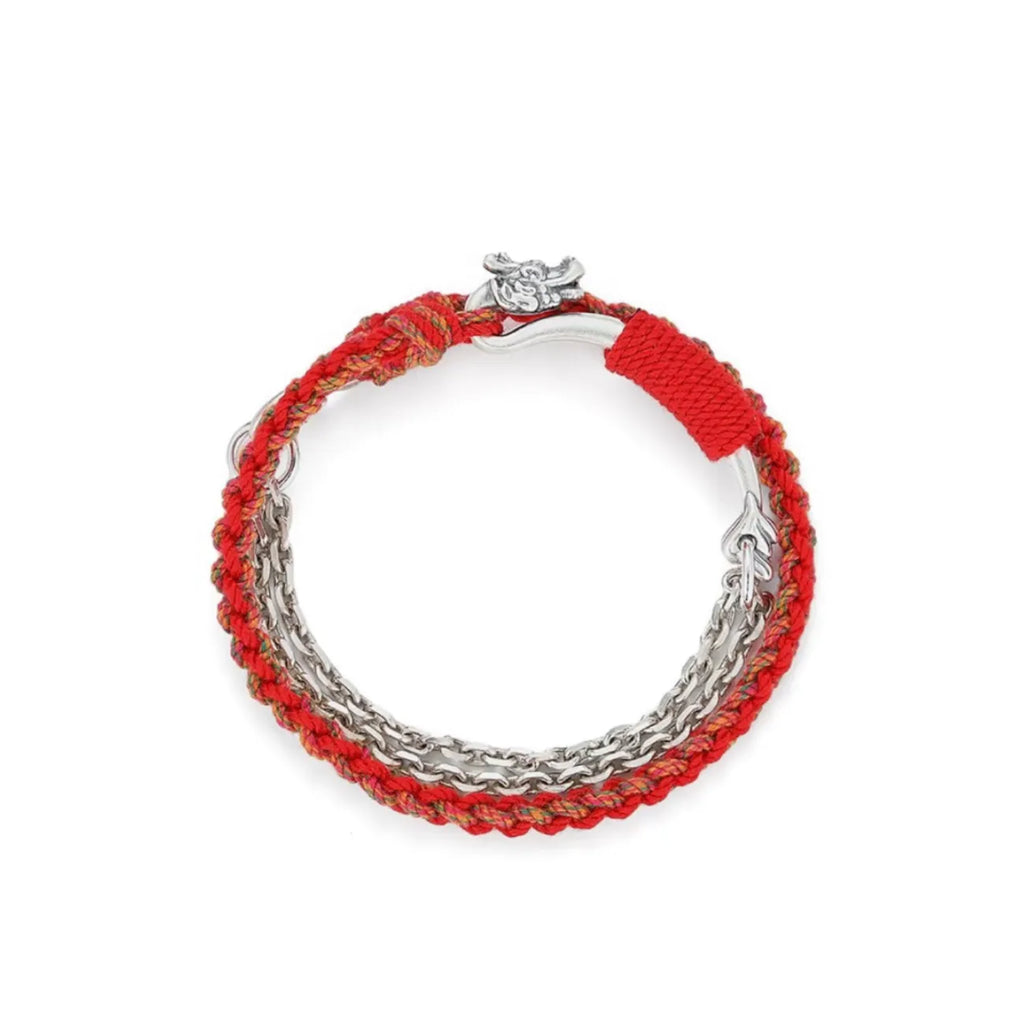 Top-down view focusing on the silver bar wrapped in red thread, symbolizing protection and good fortune