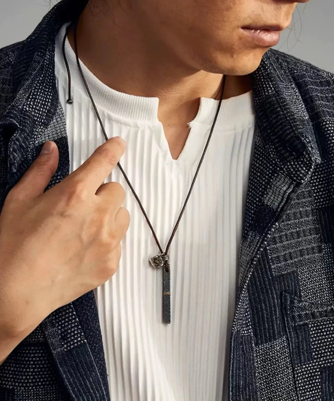 Lifestyle shot of a model wearing the Prosperous necklace, highlighting its sleek and masculine appeal