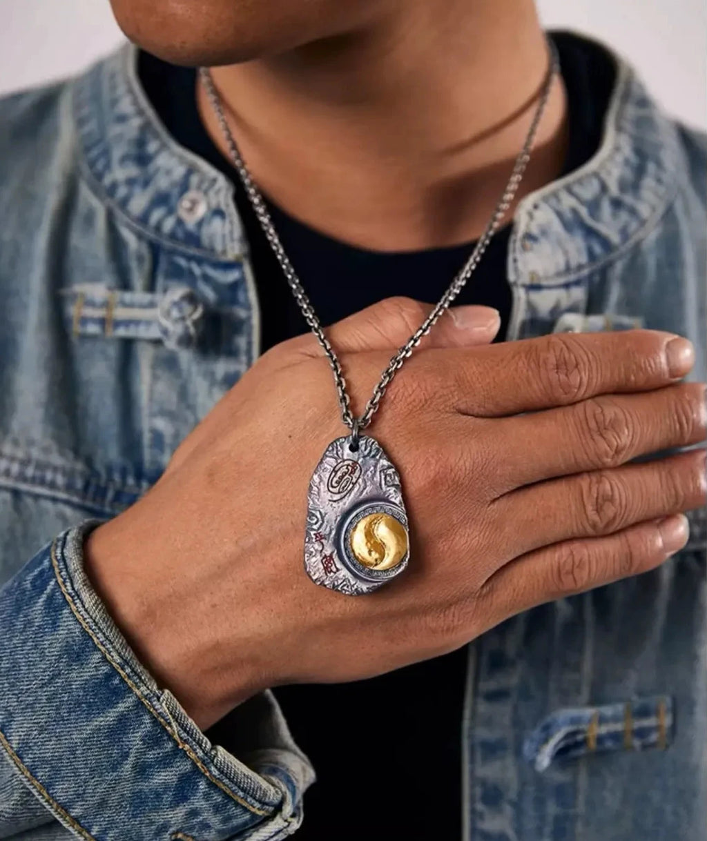 Close-up of a model holding the Taichi necklace against the chest, emphasizing the gold Yin Yang detail