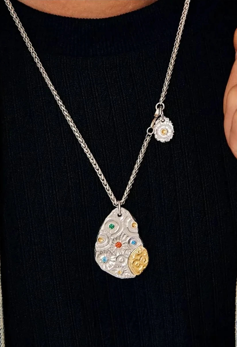 Close-up of the Starway necklace on a model, showing the blue, green, and red gemstones against a black top