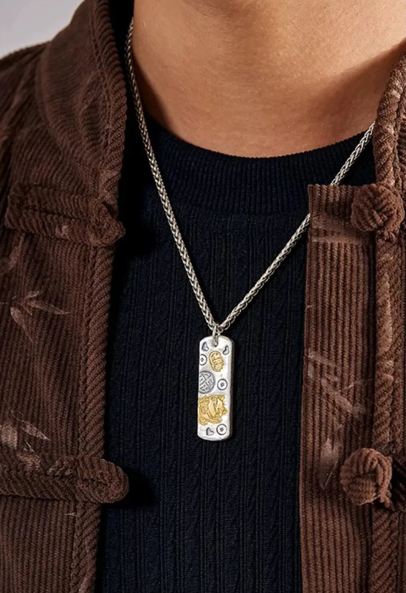 Front chest view of the maneki-neko pendant worn over a black shirt, showing the daily wear look