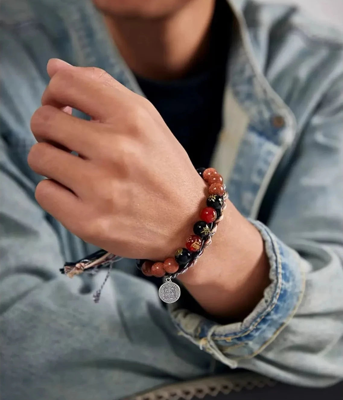 Lifestyle shot of a man wearing the Taoist bracelet with a denim jacket, blending traditional spiritual symbols with modern casual fashion