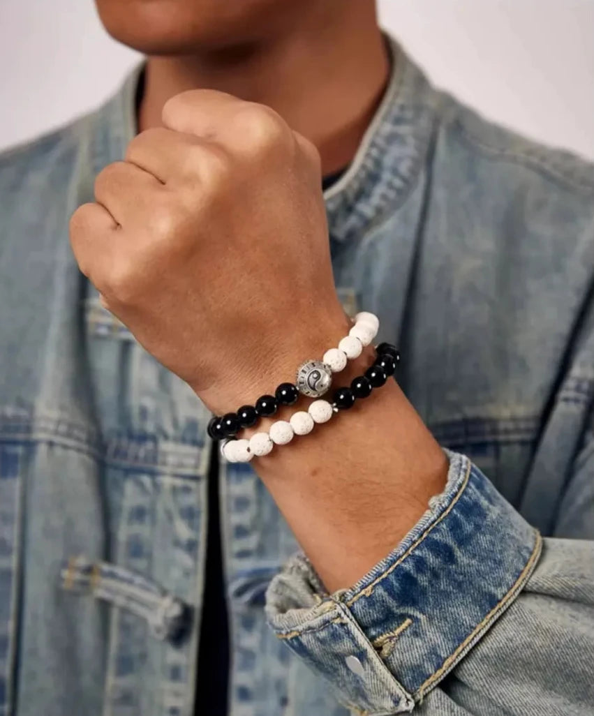 A fist pose showcasing the silver Yin Yang bead as the focal point, representing strength and equilibrium