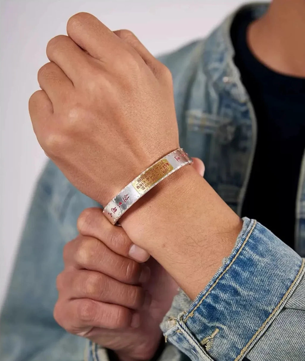 Lifestyle shot of a man wearing the Taoist talisman bangle, paired with a denim jacket to show a modern fusion style