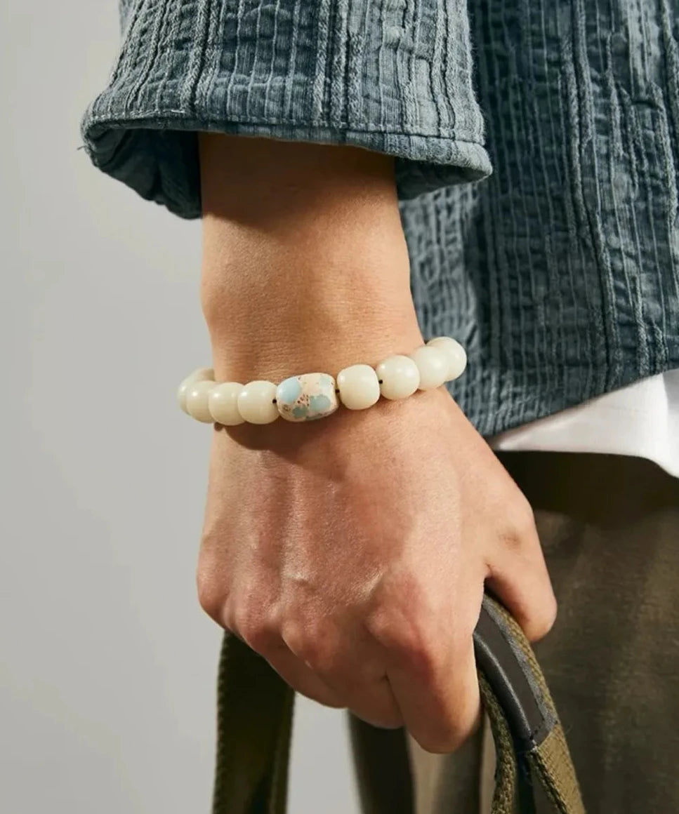 Lifestyle shot of a man holding a bag, showcasing the Imperial Jasper bead as a stylish accent for casual, organic fashion